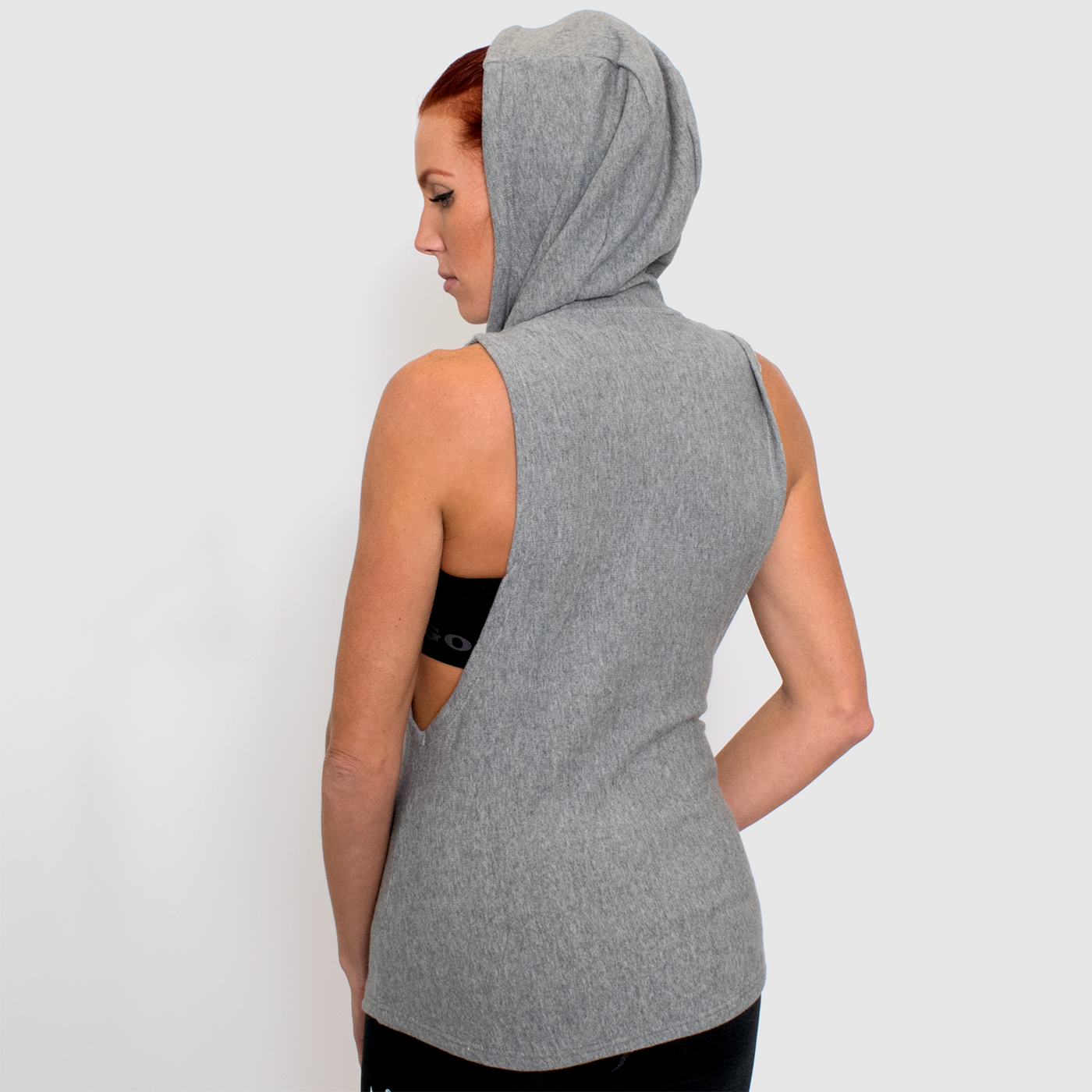 back view photo of model advance ladies sleeveless hoodie in grey. 