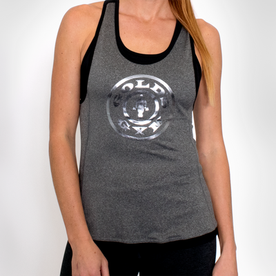 photo of model wearing ladies foil stringer in grey/black. golds gym weight plate logo in reflective silver on front.