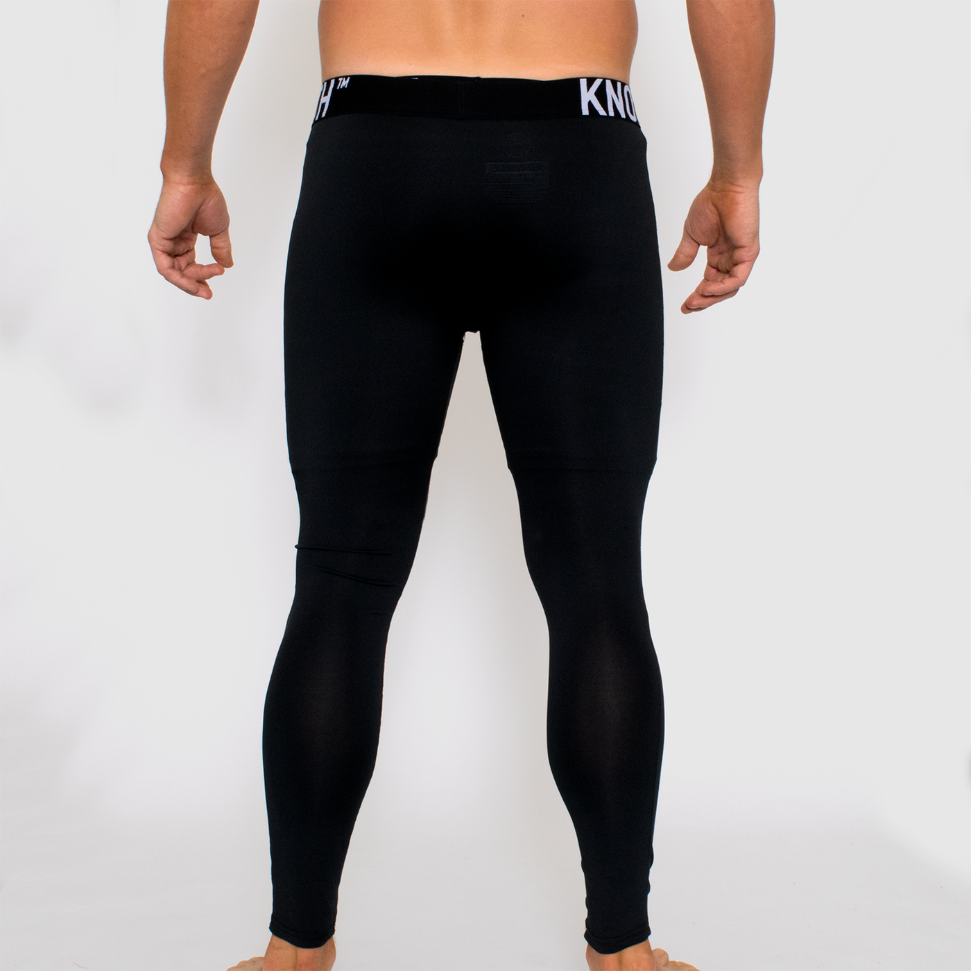 back view photo of model wearing advance mens compression tights in black. 