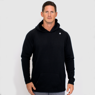 photo of model wearing advance mens fleece hoodie in black. small golds gym weight plate logo in white on upper left chest.