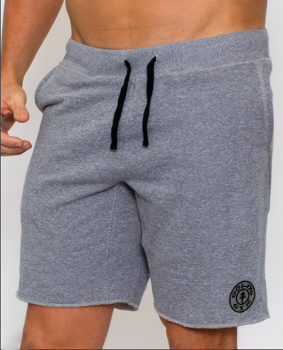 photo of model wearing advance fleece jogger short in grey heather.black drawstring tie in waistband. golds weight plate in black on left leg above knee 