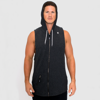 photo of model wearing advance mens sleeveless hoodie in black heather. small golds gym weight plate logo in white on upper left chest. white drawstring shown while hoodie is up. zippered pocket on right side front with muscle joe pull.