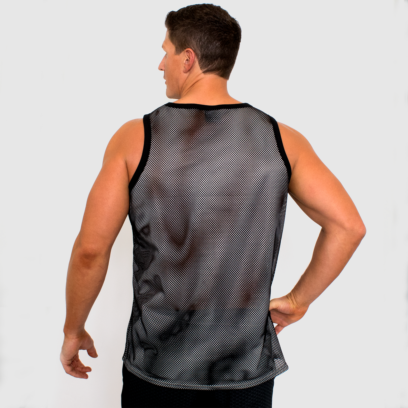 back view photo of model wearing mens double mesh tank in white black. golds gym muscle joe logo printed on front in black.