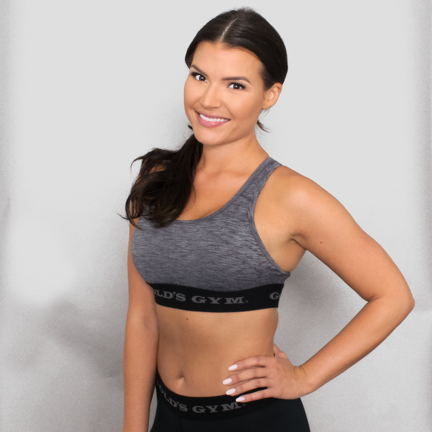 photo of model wearing advance classic bra in metal heather. golds gym printed on lower band.