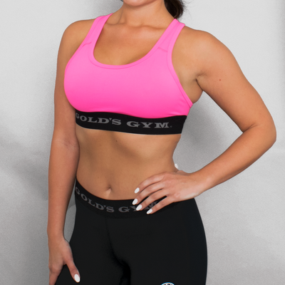 photo of model wearing advance classic bra in hot pink. golds gym printed on lower band.