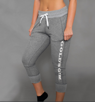 photo of model wearing advance comfy capri in athletic heather. golds gym printed vertically on left leg below pocket.